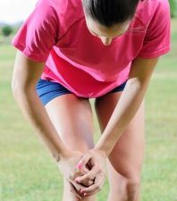 Woman Grasping Knee in Pain