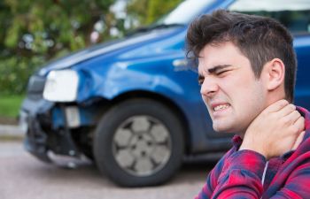 A man suffering from whiplash pain after a motor accident.